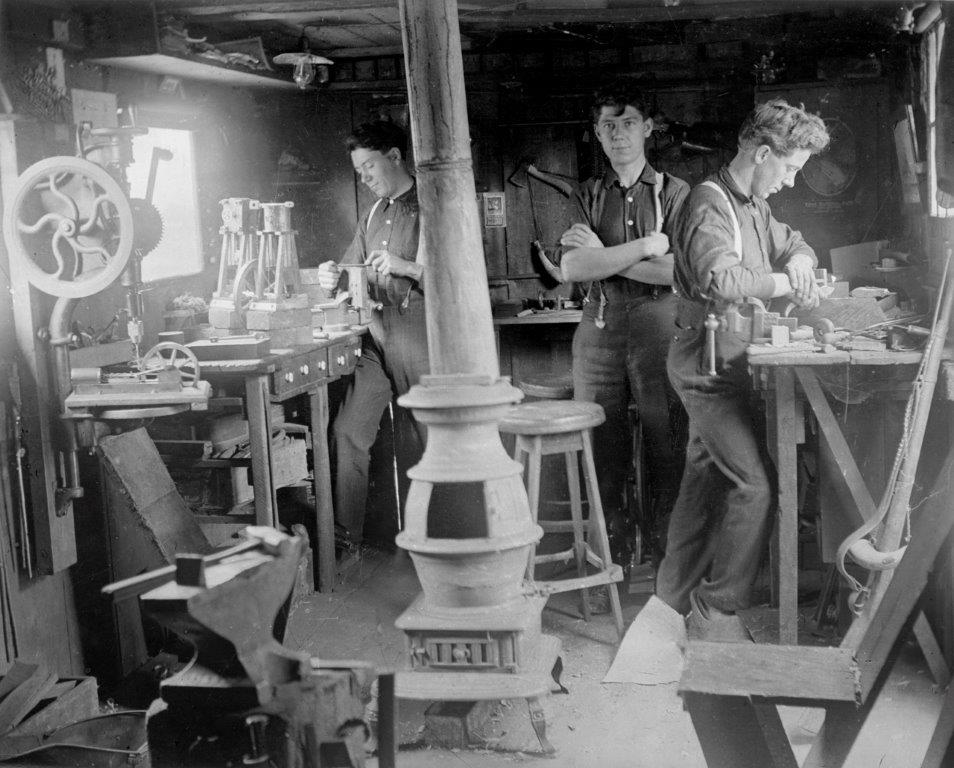 Left to right are Fritz, Jacob and Ernest Warther working in their shop in 1907. Ernest (Nicknamed Mooney) is carving on wood with an early pocketknife he made.